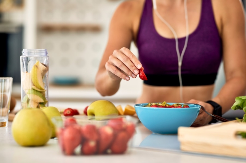 donna sportiva che mangia frutta